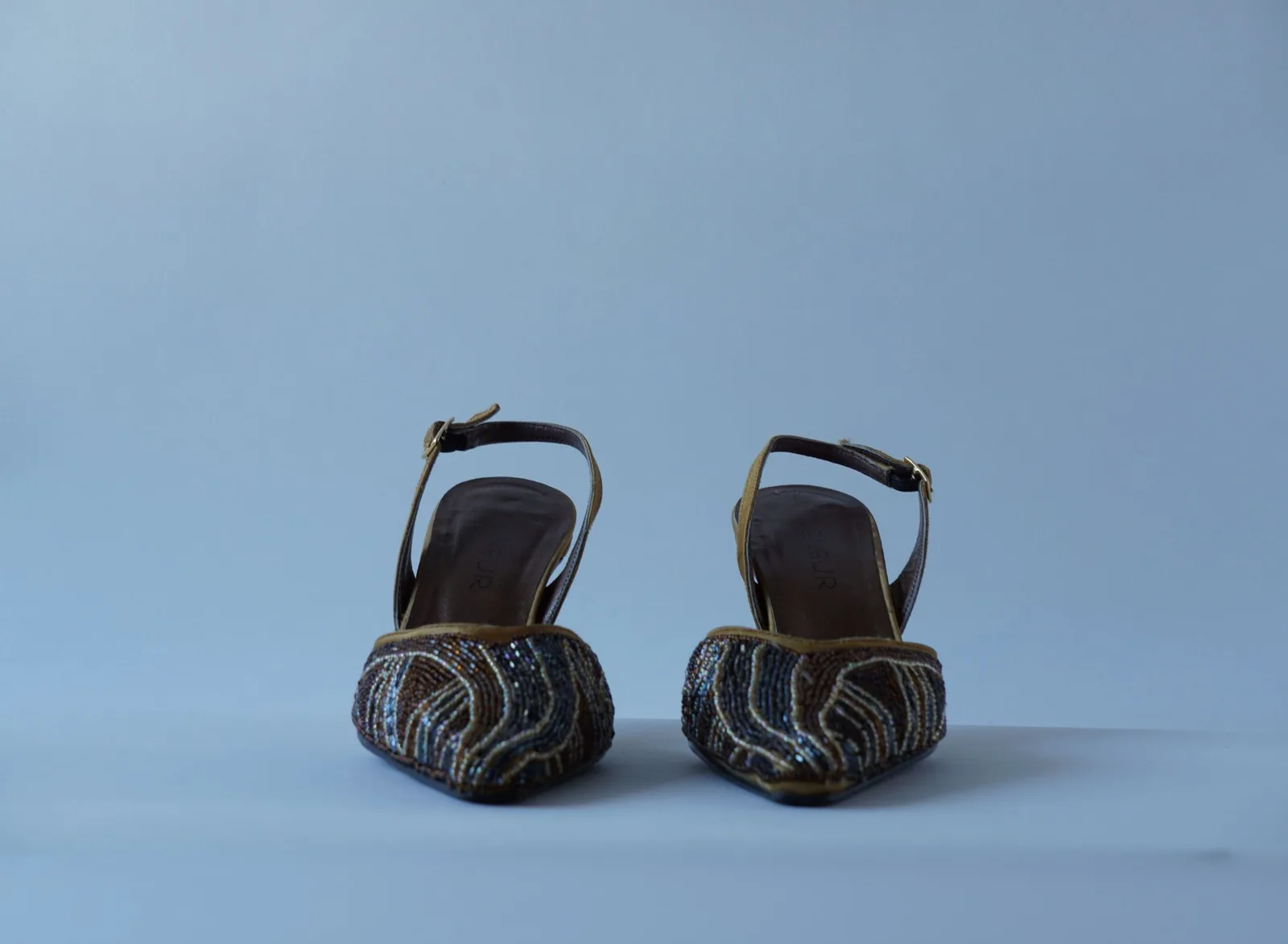 Front view of the pair of bijou heels with bronze, gold and dark beaded toes.