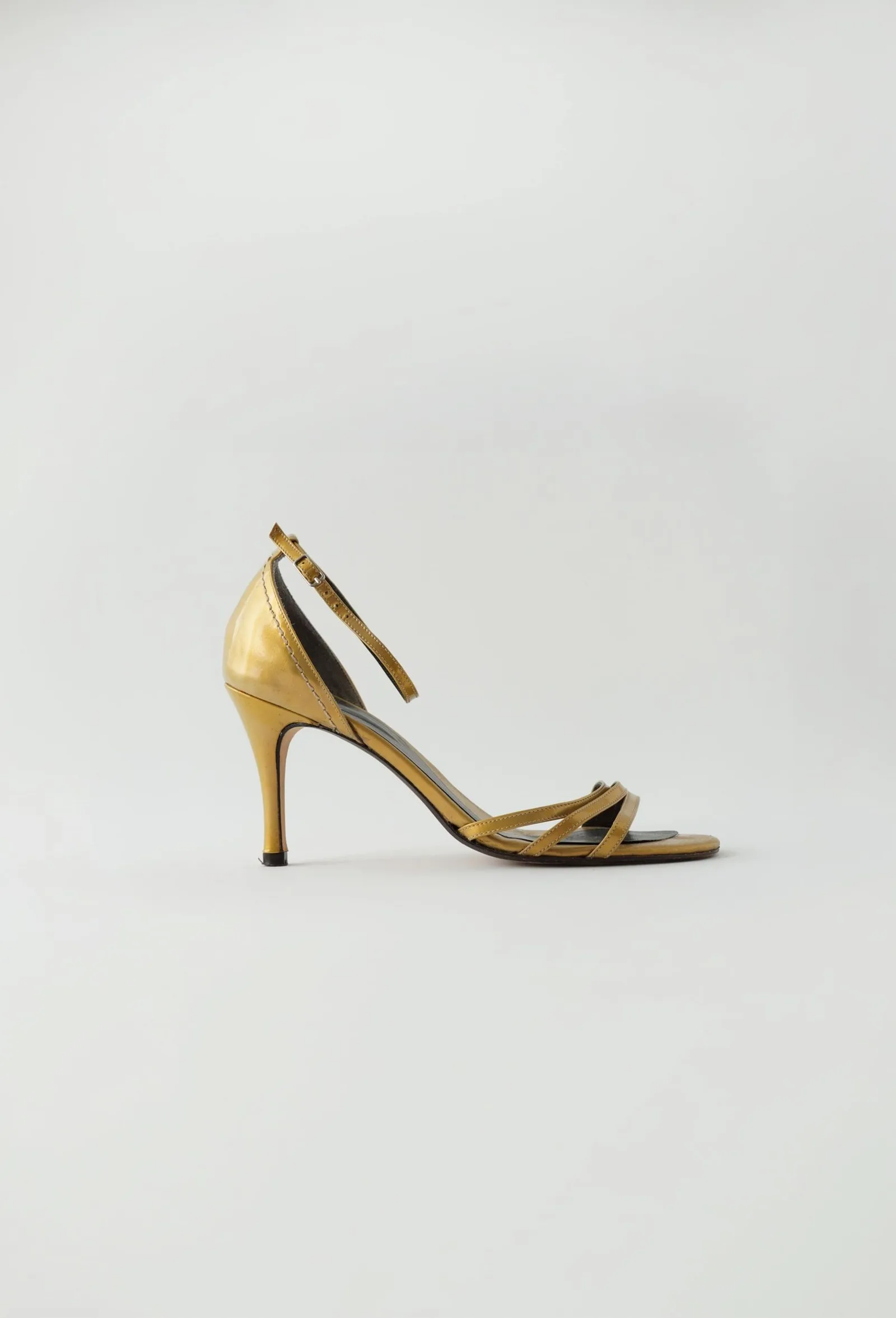 Honey-gold Mart Visser stiletto sandal with slim crossing straps and an ankle buckle, side profile.
