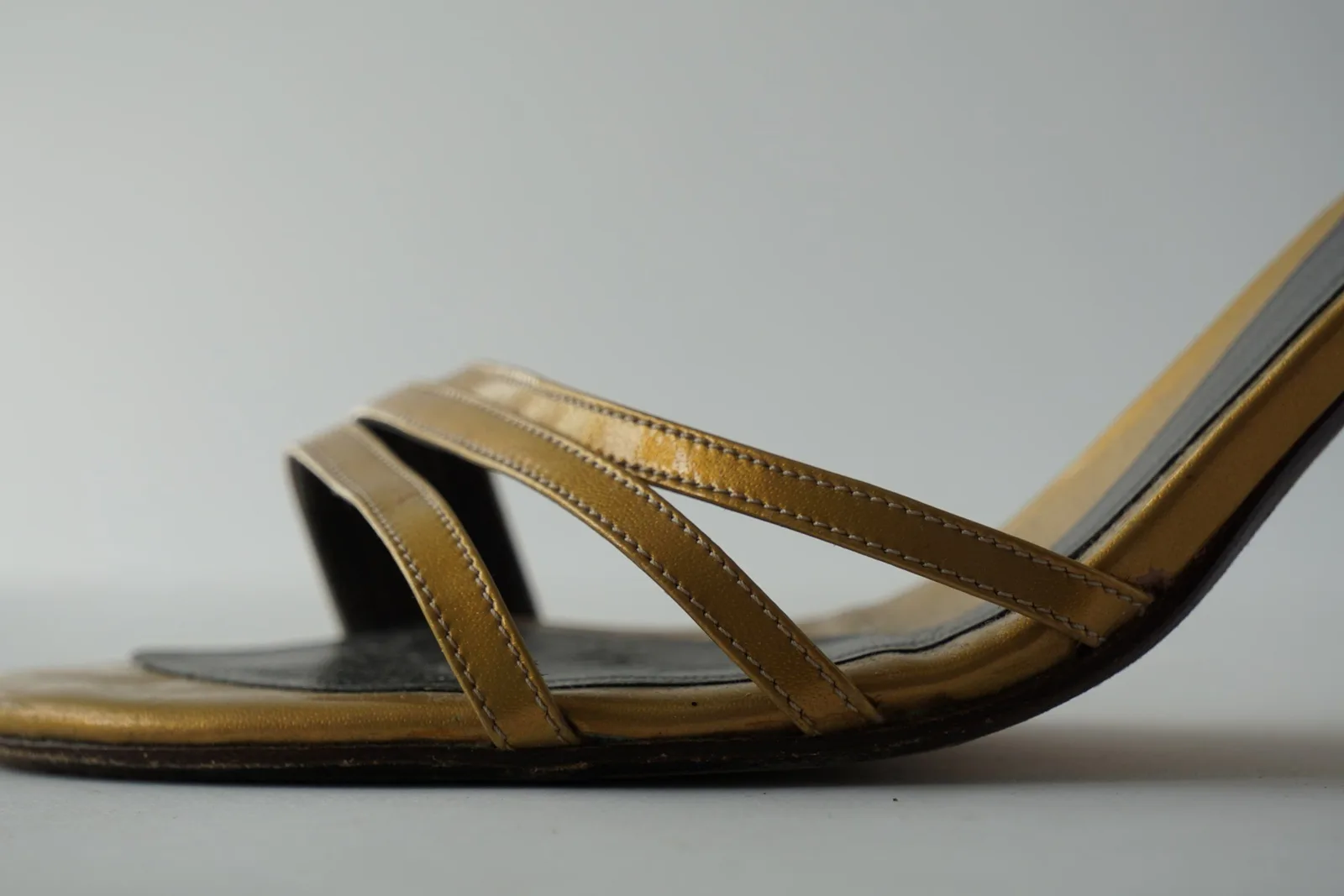 Close-up of the honey-gold crossover toe straps and leather stitching.