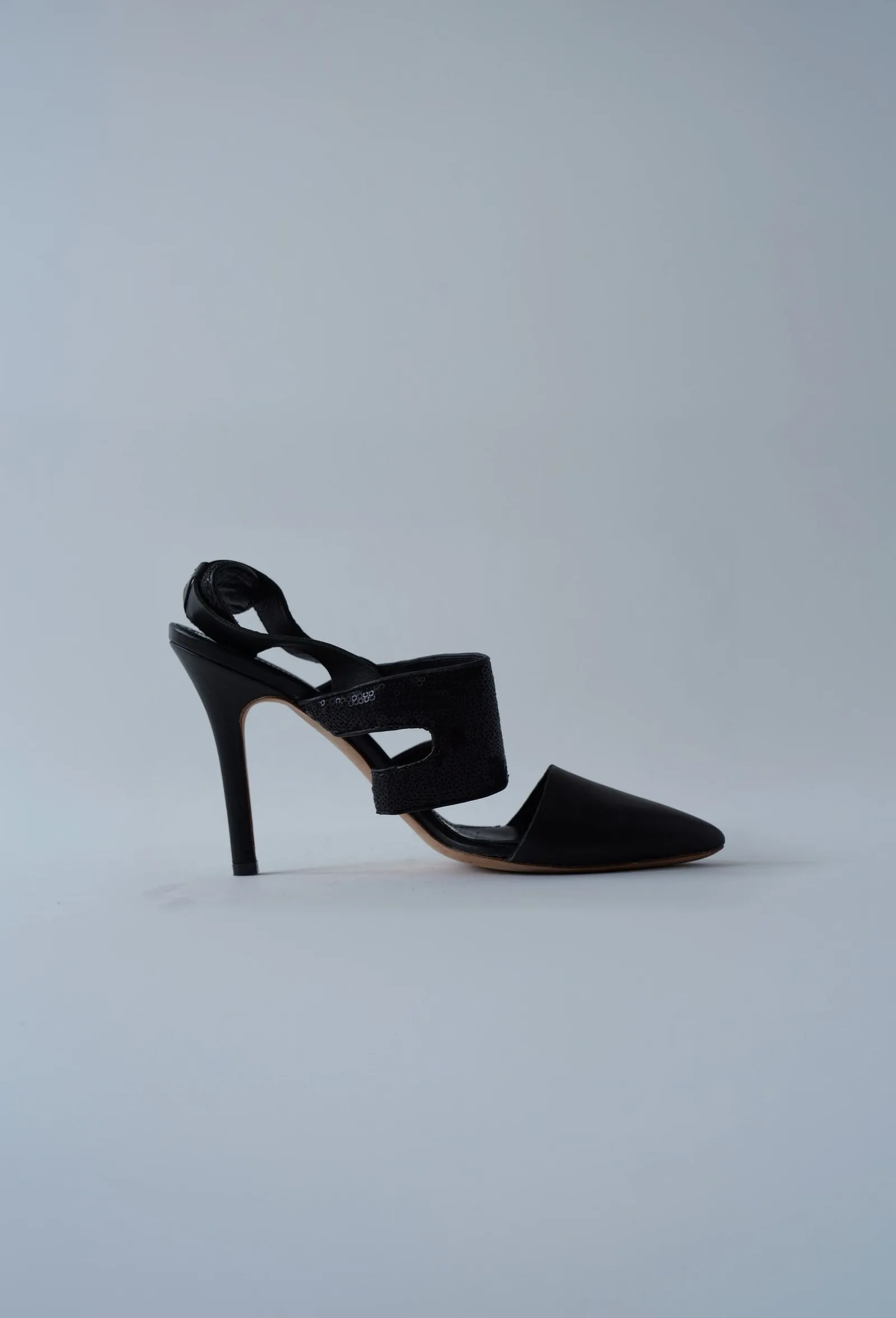Black Alexander McQueen pointed-toe slingback heel with broad sequinned straps, side profile.