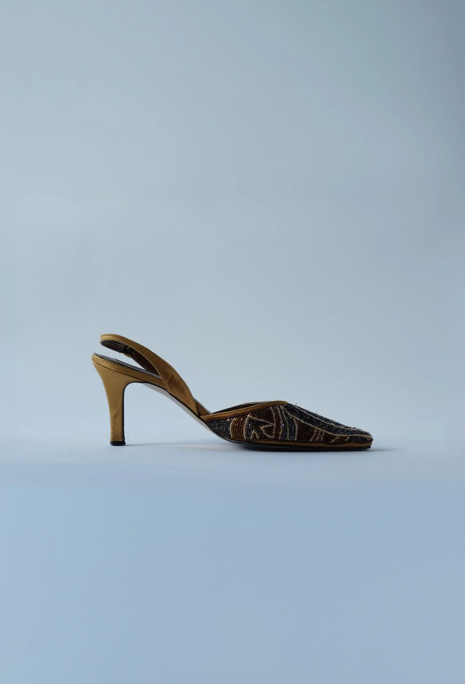 Bronze and gold beaded pointed-toe slingback heel with a golden heel, side profile.